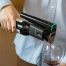 Coravin wine preservation device in hand used to pour red wine