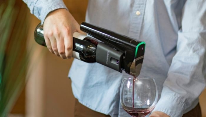 Coravin wine preservation device in hand used to pour red wine